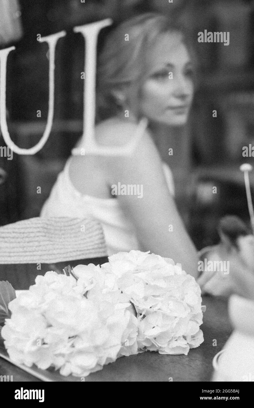 Un concetto ben pensato. Bella donna elegante in un caffè, guarda attraverso il vetro della finestra. Messa a fuoco selettiva soft. Foto Stock