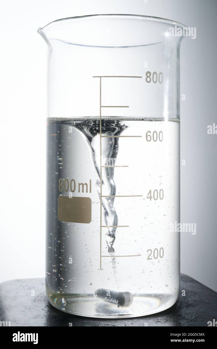 Tema dell'esperimento chimico. Pallone su agitatore magnetico con liquido a forma di tornado Foto Stock