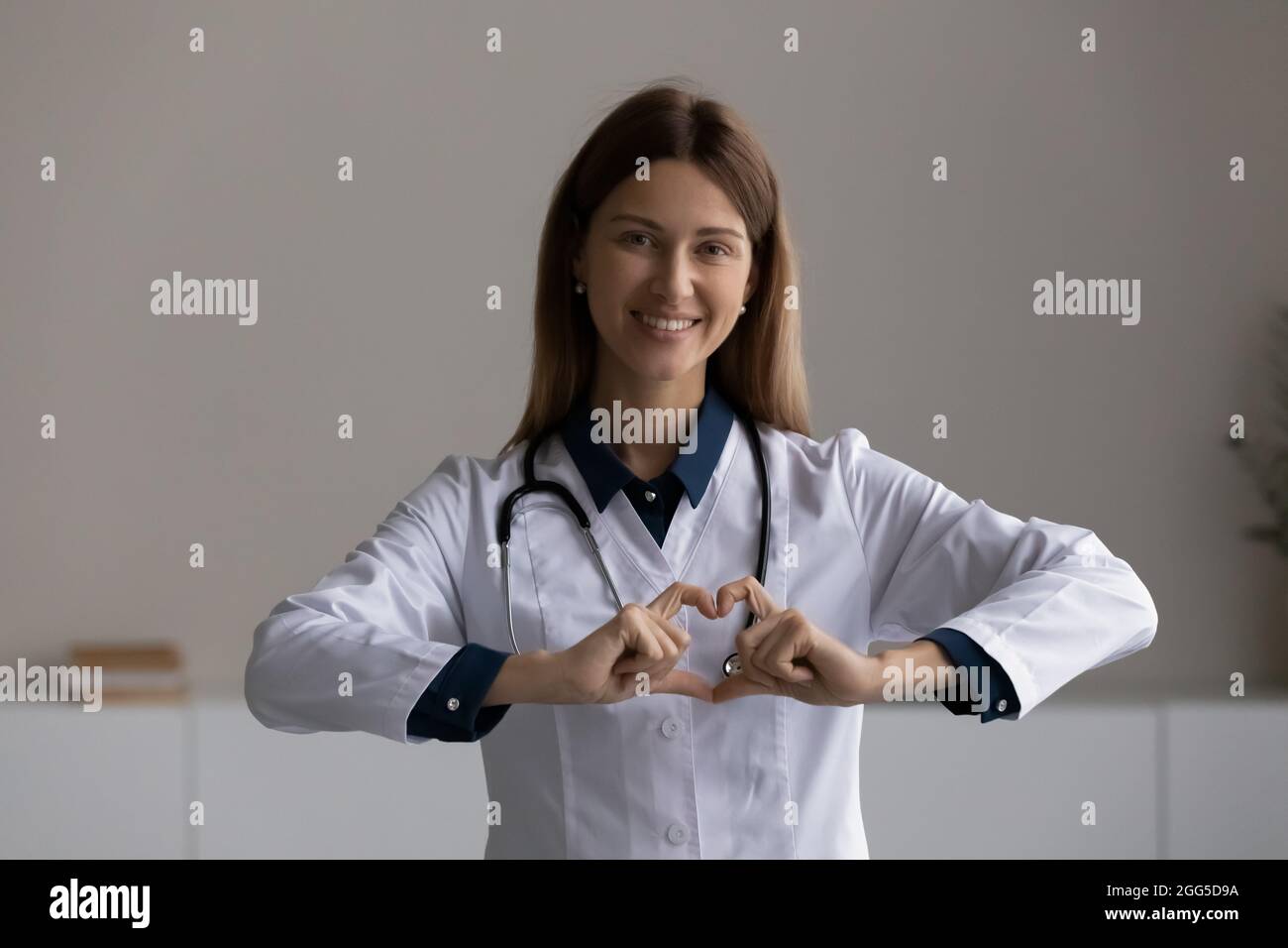 Felice sincero gentile medico femminile mostrando amore. Foto Stock