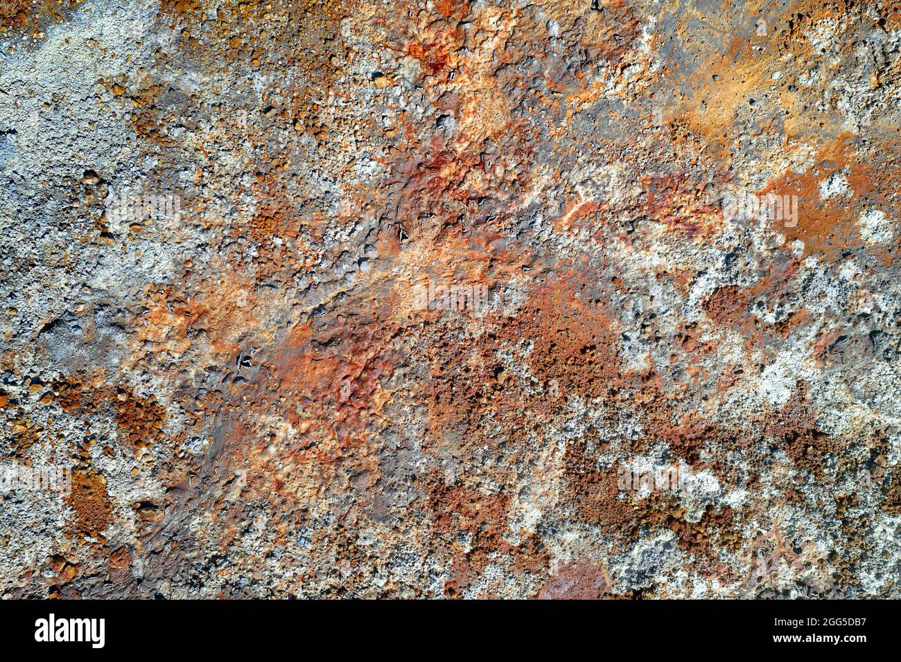 Superficie di pietra ruvida con macchie di rosso arrugginito e grigio. Texture colorata in vecchia miniera di rame Foto Stock