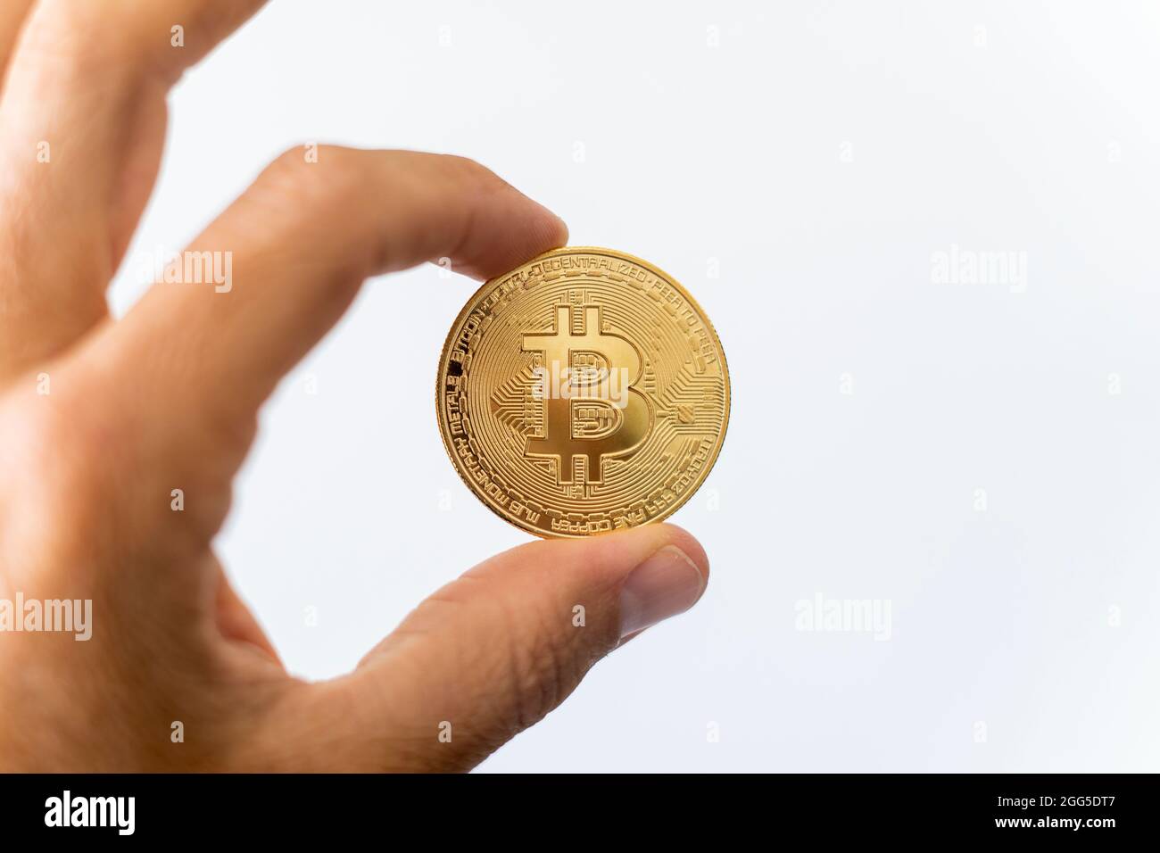 Bitcoin cripto valuta tenuta. Moneta d'oro con simbolo BTC. Tecnologia Blockchain. Bitcoin aumento di prezzo o crash. Investire in risorse virtuali. Foto Stock