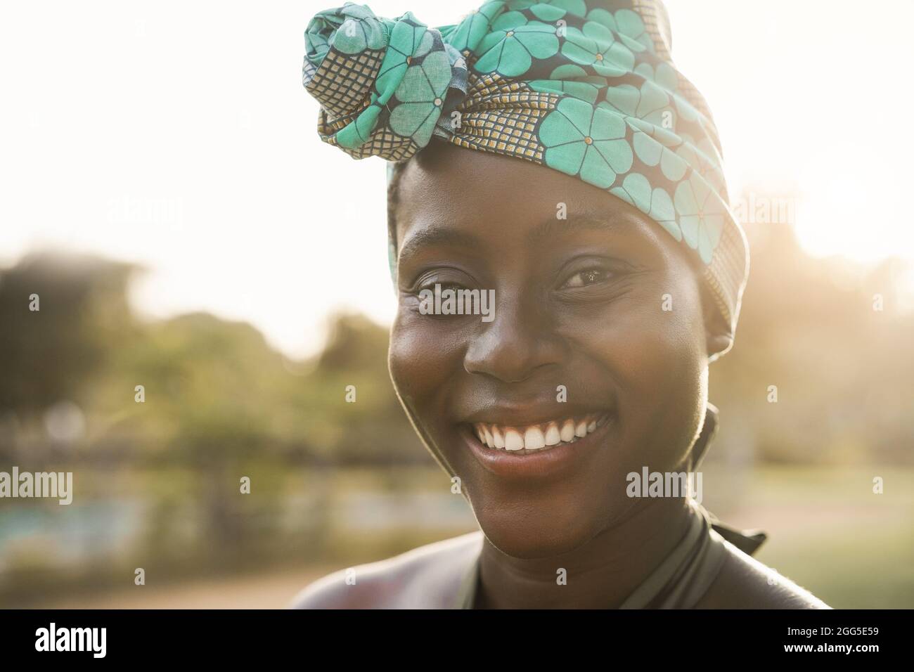 Donna afroamericana che sorride con la macchina fotografica all'aperto al parco cittadino - Focus on Mouth Foto Stock