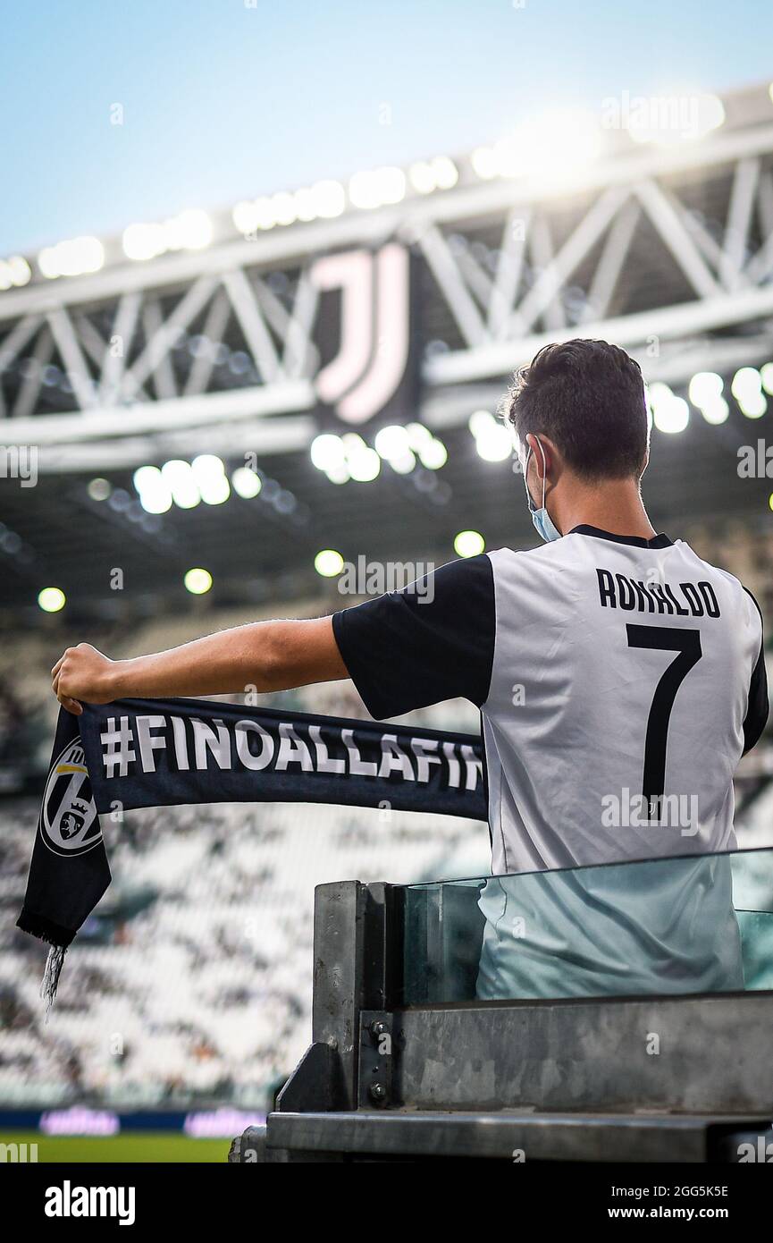 Torino, Italia. 28 agosto 2021. Un fan della Juventus FC che indossa una  maglia con il nome di Cristiano Ronaldo tiene una sciarpa con il motto  Juventus FC 'fino alla fine ('fino