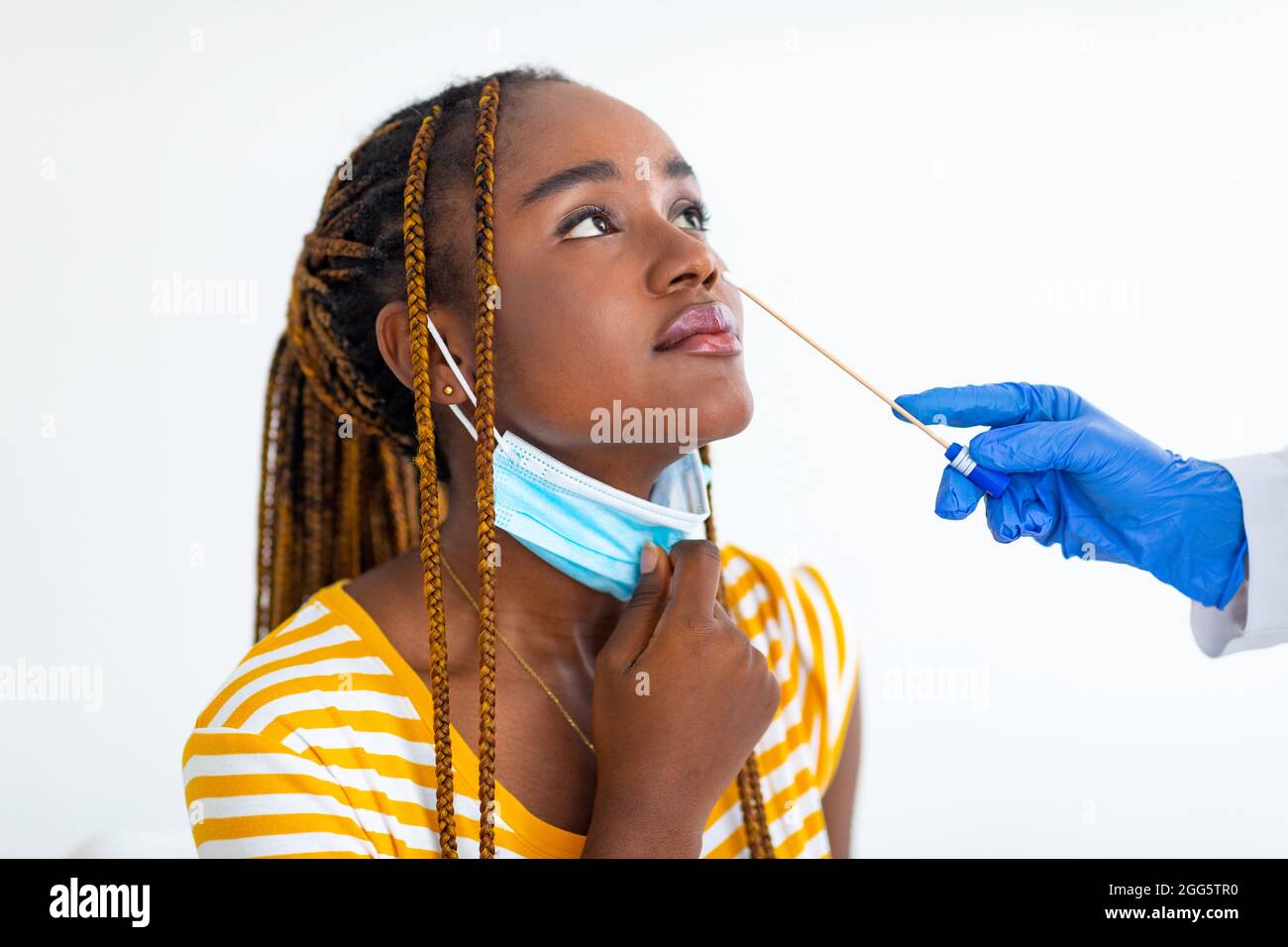 Nurse mani fare PCR nasale test per la donna afro americana Foto Stock