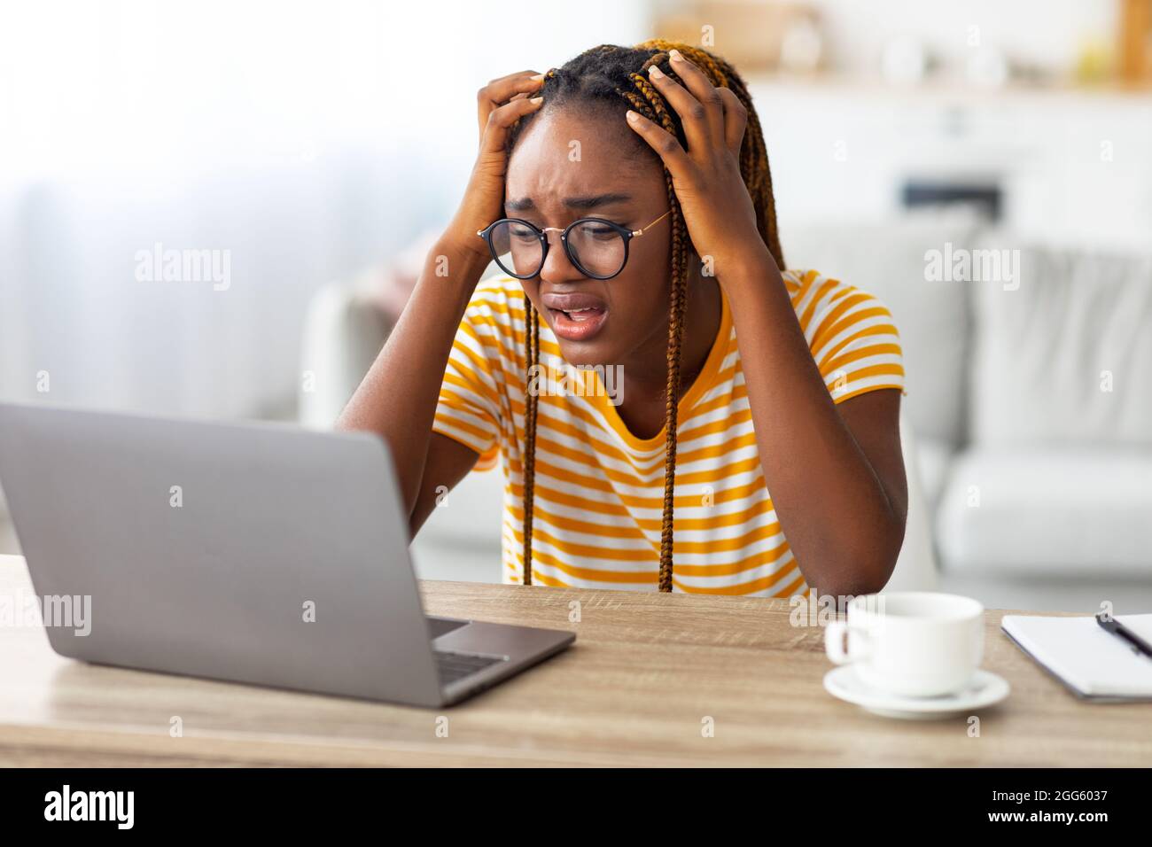 Stressante donna nera freelancer che lavora da casa Foto Stock