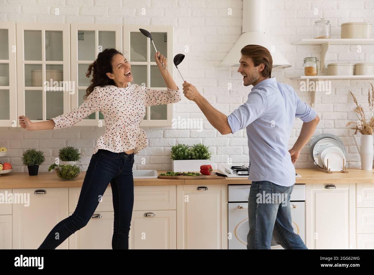 Felice giovane coppia di famiglia divertirsi in cucina moderna. Foto Stock