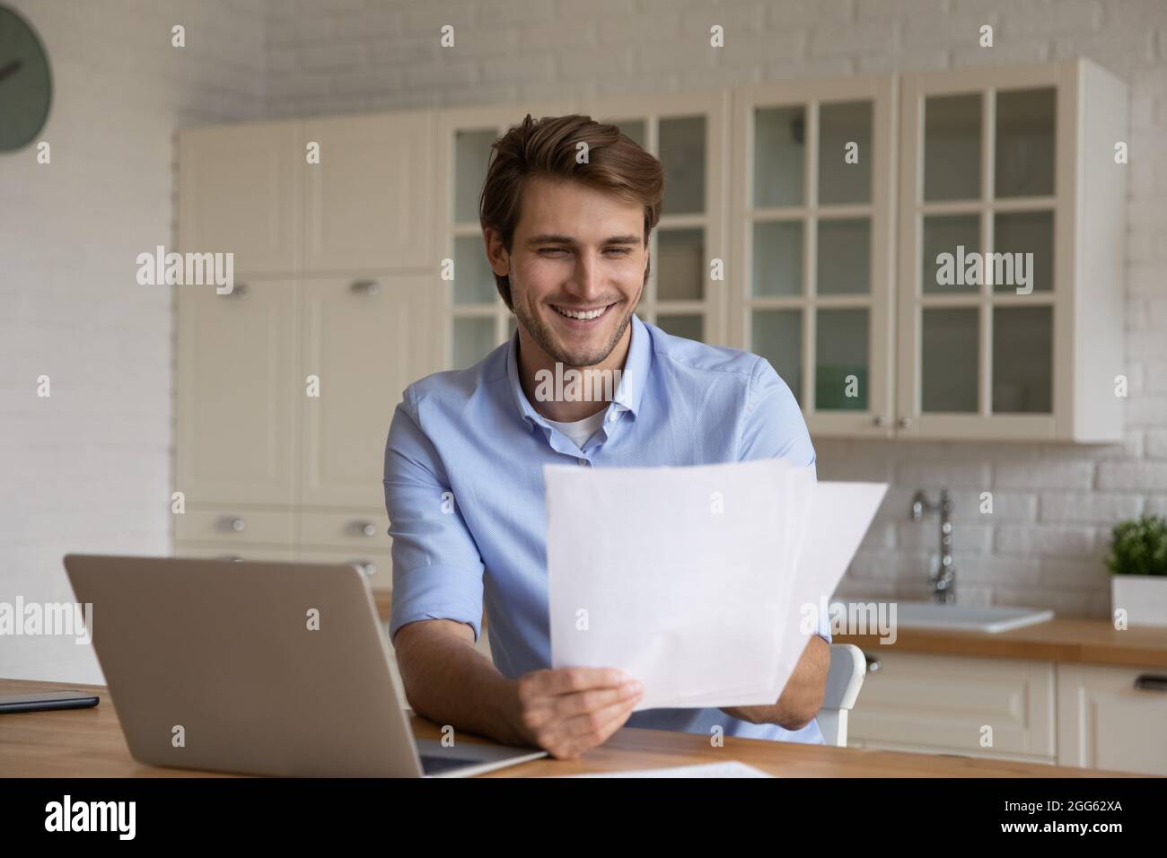 Buon uomo d'affari giovane leggendo la carta con buone notizie. Foto Stock