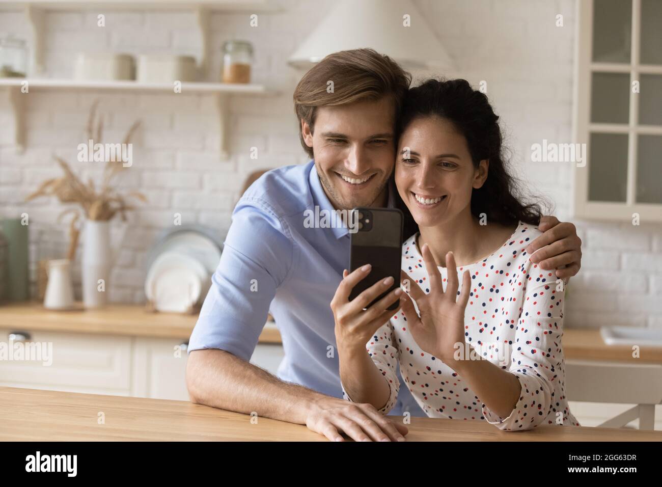 Felice legame con la coppia di famiglia millennial che usa lo smartphone. Foto Stock