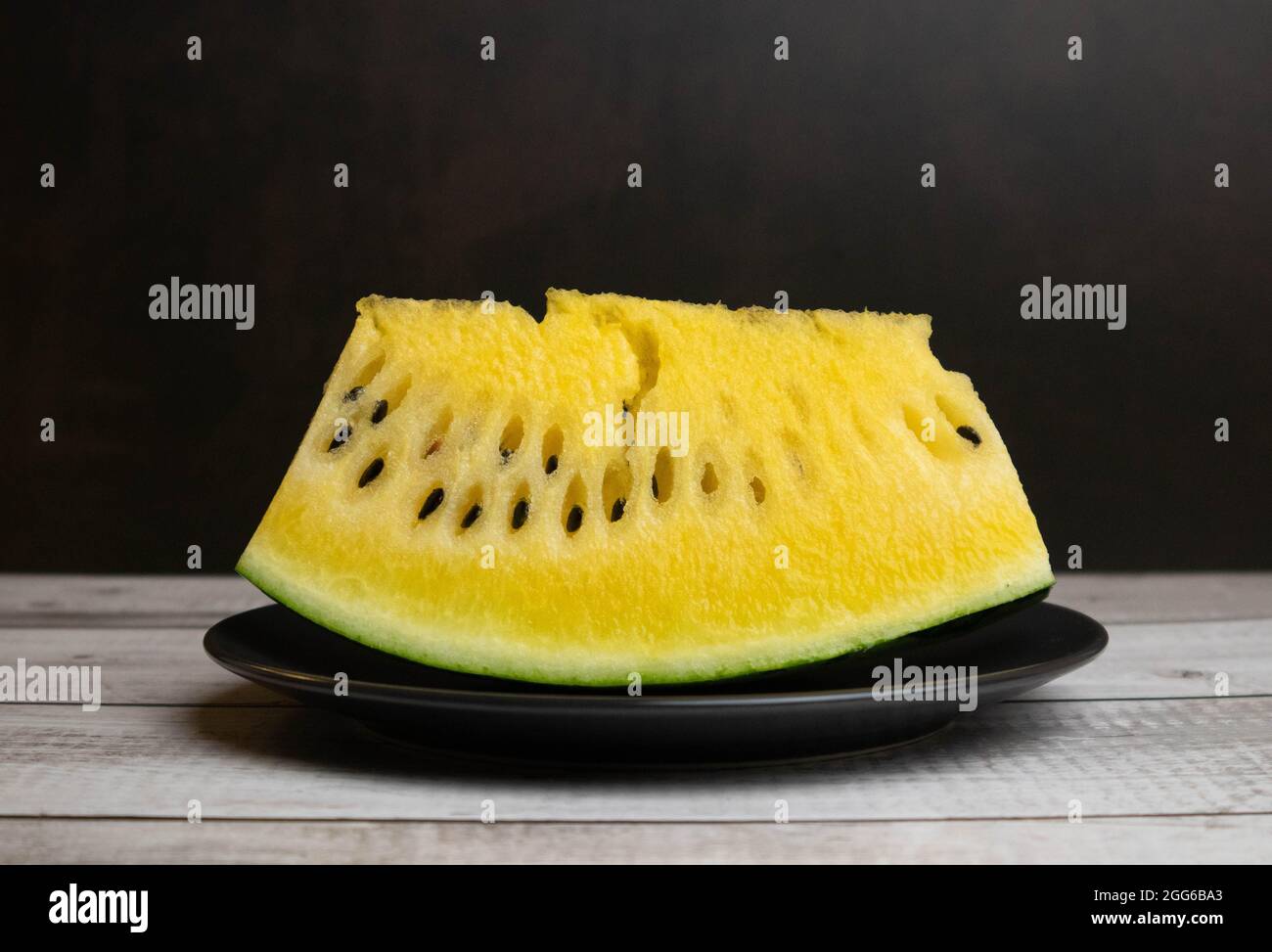 Anguria gialla su piatto nero, pensa diverso. Foto di alta qualità Foto Stock