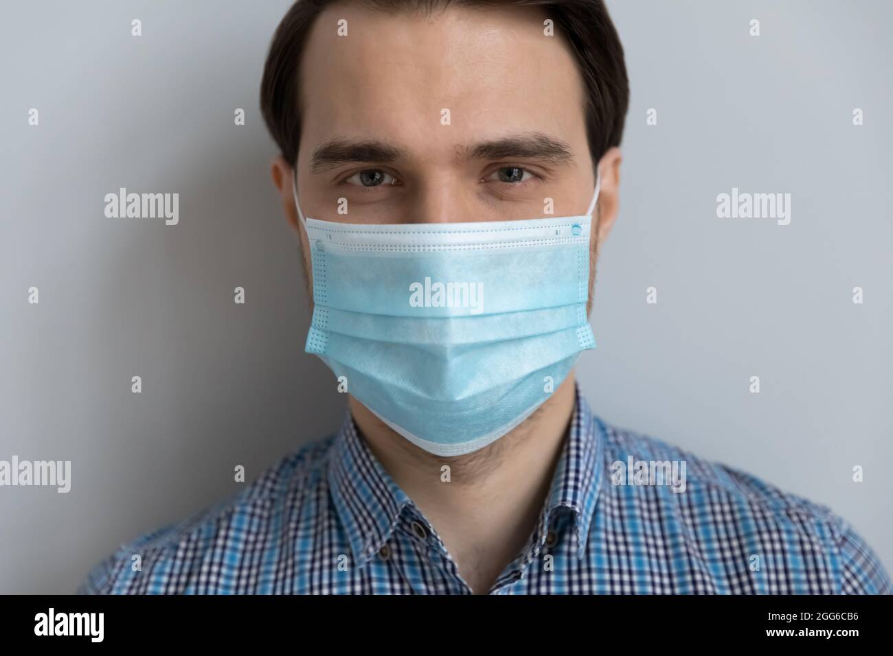 Bel giovane uomo in maschera medica protettiva sulla faccia inferiore Foto Stock