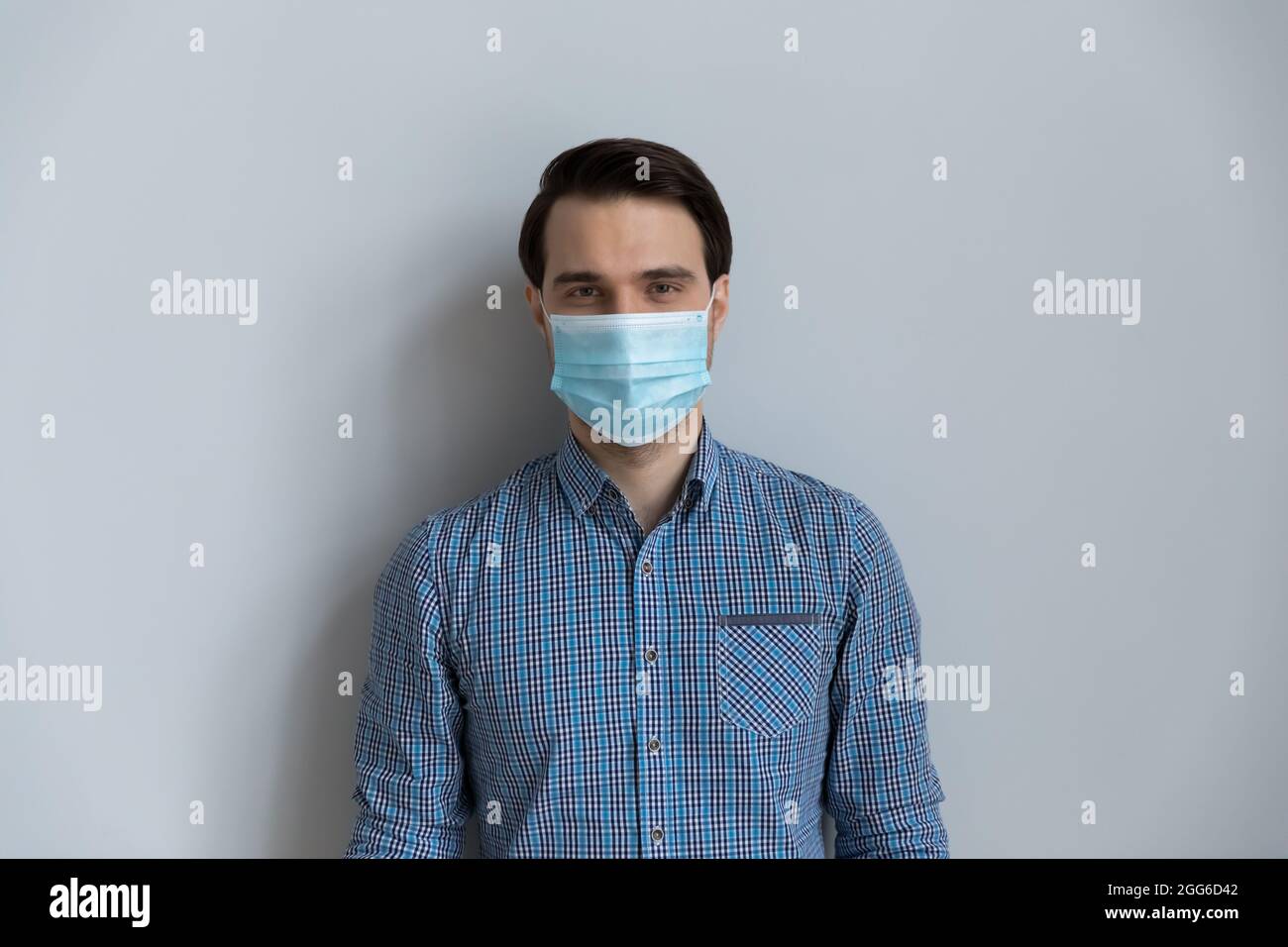 Ritratto di uomo millenario indossare maschera medica sul viso Foto Stock