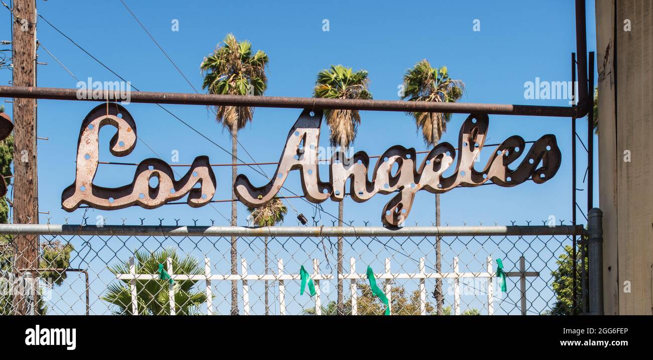 'Los Angeles' segno di lettere metalliche, appeso a una ringhiera in un cantiere di salvataggio architettura. Foto Stock
