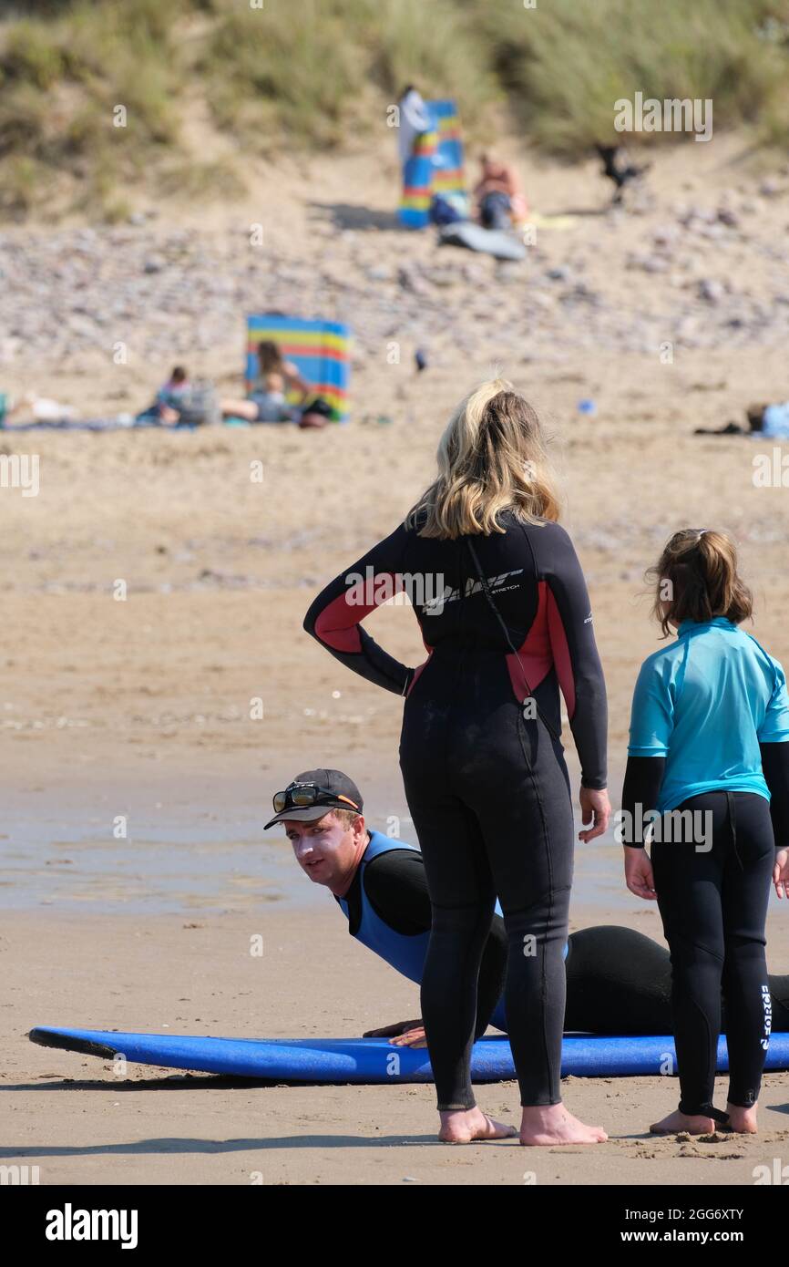 Gower, Swansea, Regno Unito. 29 agosto 2021. Meteo Regno Unito. Imparare a navigare con una scuola di surf in un caldo e soleggiato week-end di vacanza in banca alla spiaggia di Llangennith sulla penisola di Gower. Il resto del fine settimana di festa della banca è previsto per essere altrettanto bene nel sud del paese. Credit: Gareth Llewelyn/Alamy Foto Stock