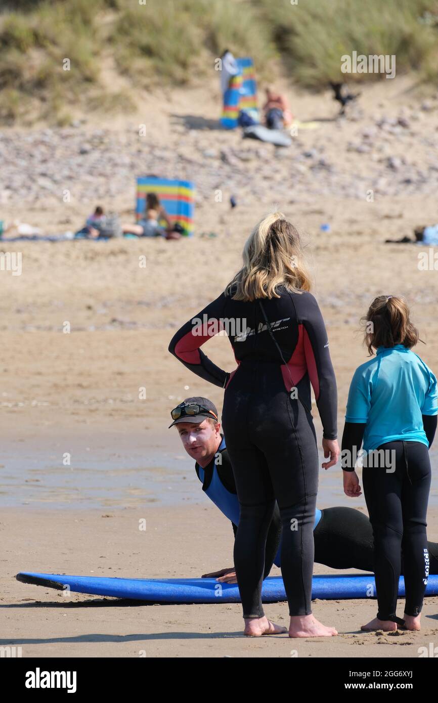 Gower, Swansea, Regno Unito. 29 agosto 2021. Meteo Regno Unito. Imparare a navigare con una scuola di surf in un caldo e soleggiato week-end di vacanza in banca alla spiaggia di Llangennith sulla penisola di Gower. Il resto del fine settimana di festa della banca è previsto per essere altrettanto bene nel sud del paese. Credit: Gareth Llewelyn/Alamy Foto Stock