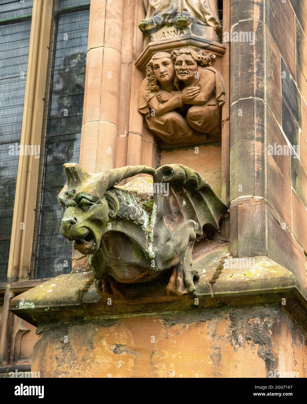 Gargoyle e altre sculture all'esterno della cattedrale di Lichfield con drago temibile e una coppia accoccolata insieme nella paura - Staffordshire UK Foto Stock