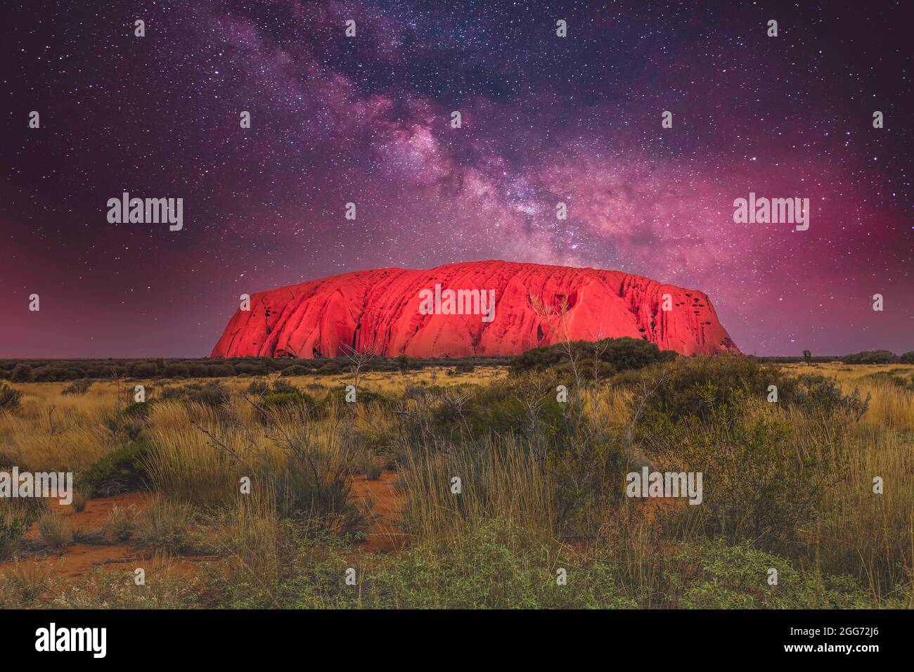 Paesaggio notturno di Uluṟu, Ayers Rock, nell'Outback del territorio settentrionale dell'Australia, sullo sfondo di un cielo stellato chiaro e brillante Foto Stock