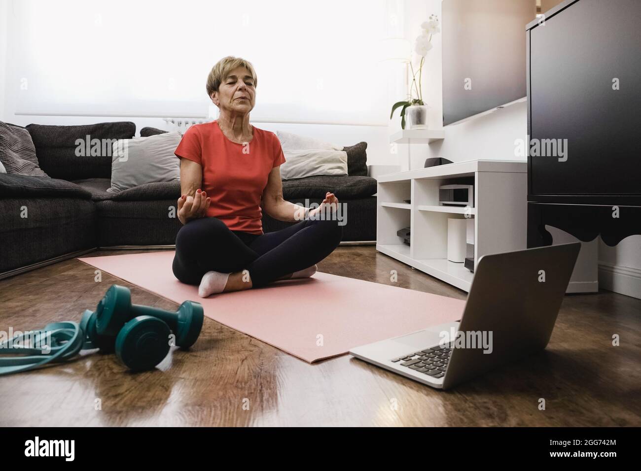 Donna anziana che fa la lezione di yoga in linea nel paese - stile di vita sano e mentalità concetto anziano - fuoco sul volto Foto Stock