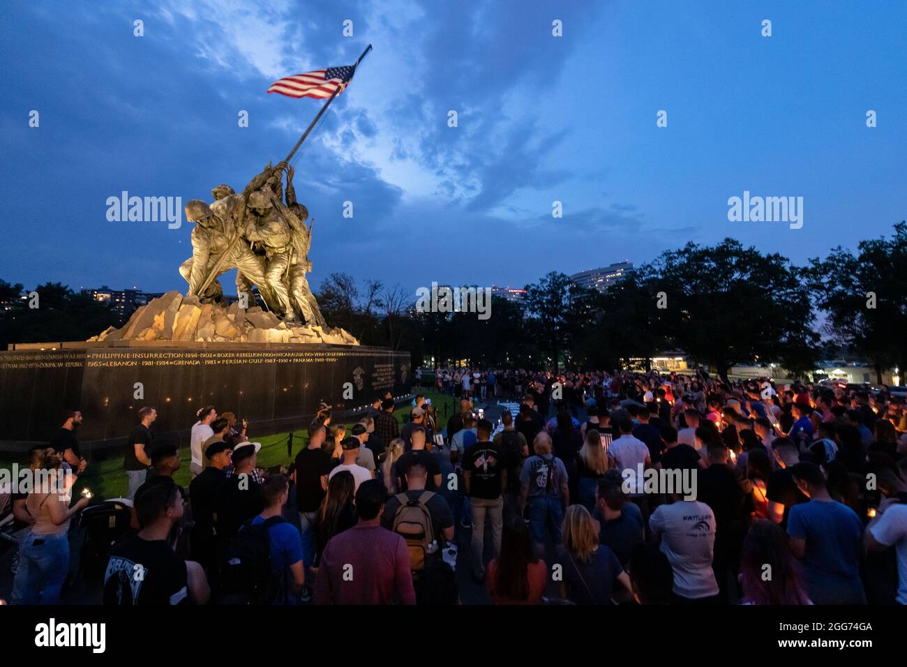 Un grande gruppo di persone si riuniscono al Marine Corps War Memorial degli Stati Uniti per una veglia a lume di candela, sabato 28 agosto 2021, in memoria dei 11 marines, un corpsman della Marina e un soldato dell'Esercito degli Stati Uniti che hanno perso la vita il 26 agosto 2021, durante un attacco a Kabul, Afghanistan. (STATI UNITI Foto del corpo marino di staff Sgt. Kelly L. Timney) Foto Stock