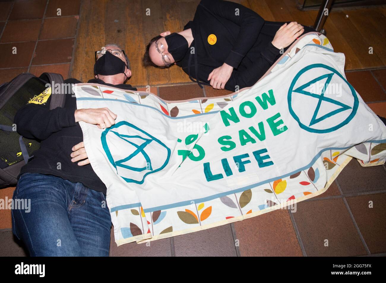 Londra, Inghilterra, Regno Unito 29 agosto 2021 gli attivisti della ribellione di estinzione tengono un Die-in e D del museo della scienza si bloccano alle ringhiere in protesta ai conchiglie che finanziano la loro mostra climatica credito: Denise Laura Baker/Alamy Live News Foto Stock