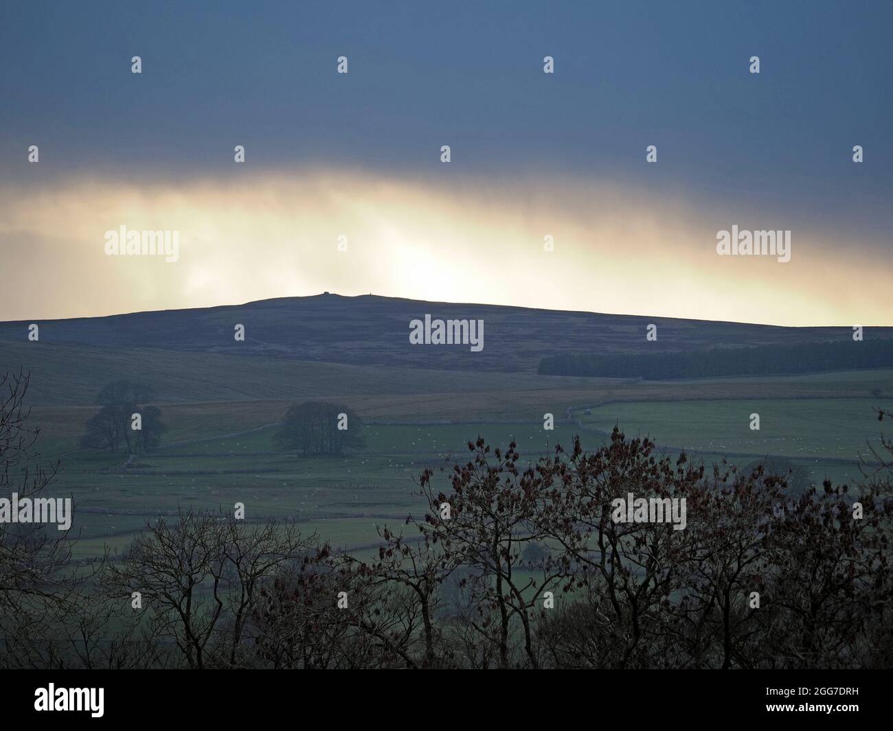 La drammatica luce tempesta su Crosby Ravensworth cadde con la luce dorata che si infranse attraverso la oscurità grigia sopra Shap Summit, Cumbria Inghilterra, Regno Unito Foto Stock