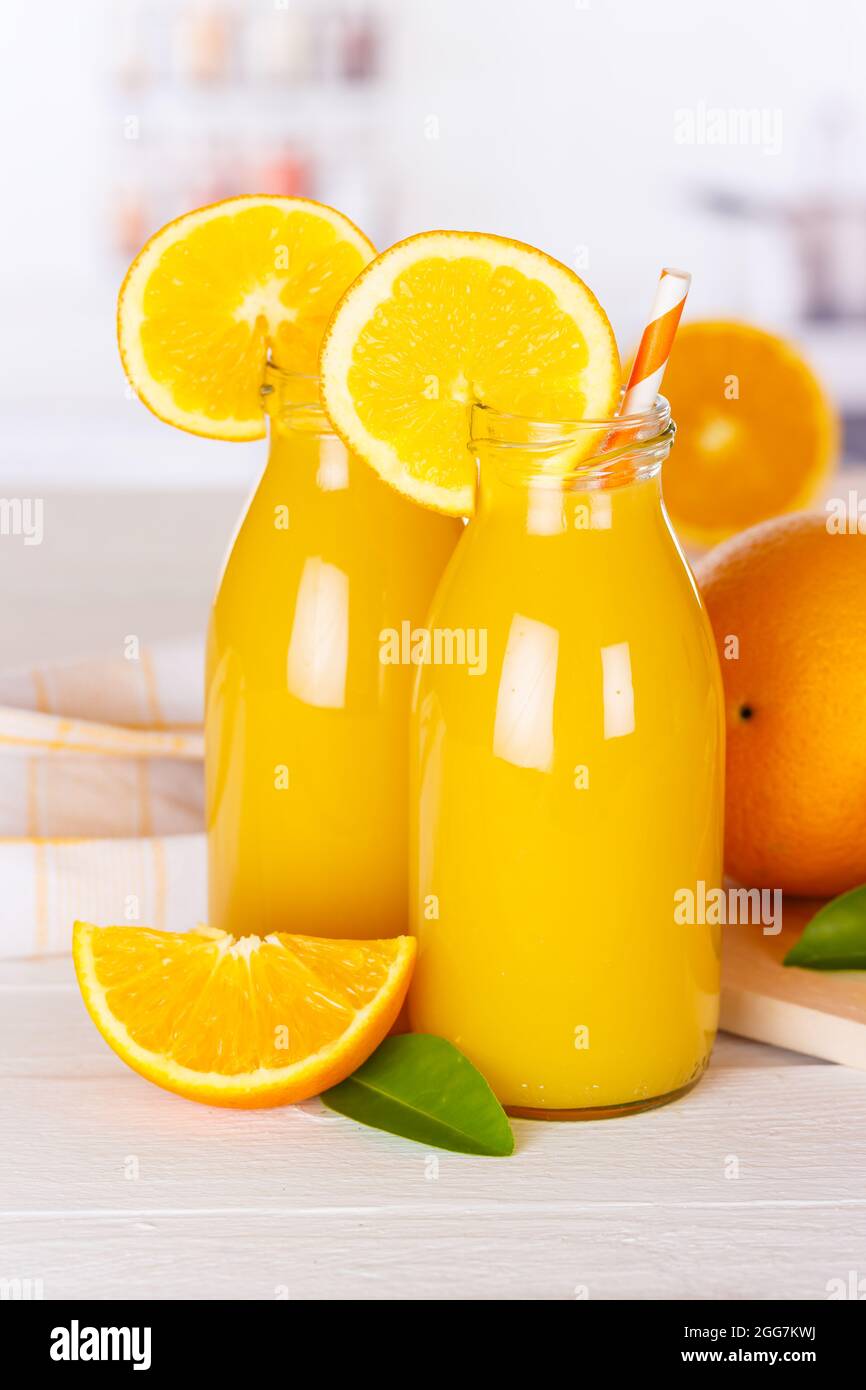 Succo d'arancia bevanda in bottiglia su tavola di legno ritratto arance formato Foto Stock