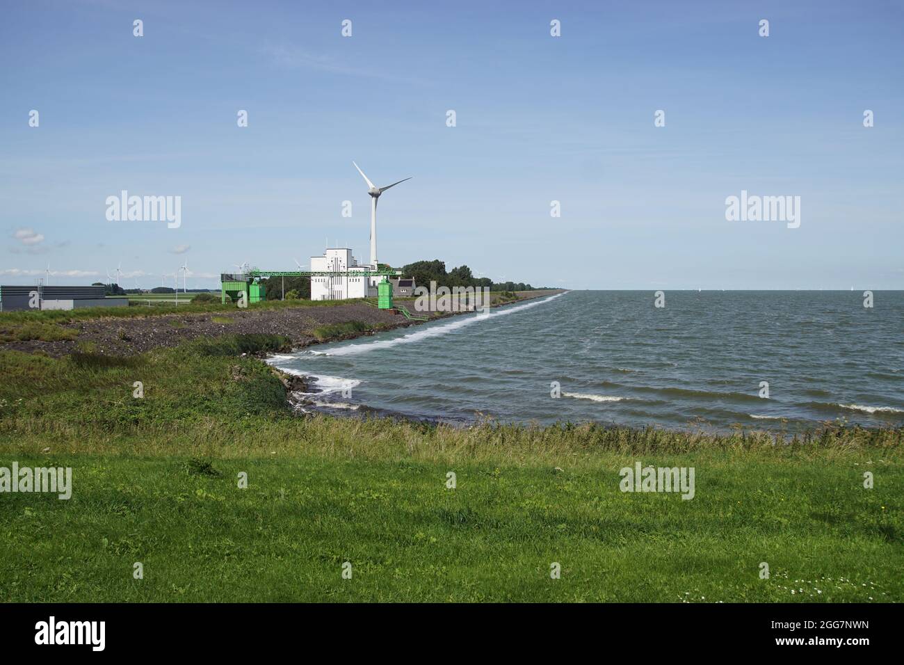 Stazione di pompaggio bianco azionata elettricamente (chiamata Lely) dal 1930 utilizzato per mantenere il polder (Wieringermeer) asciutto e mulino a vento. Città olandese Medemblik Foto Stock