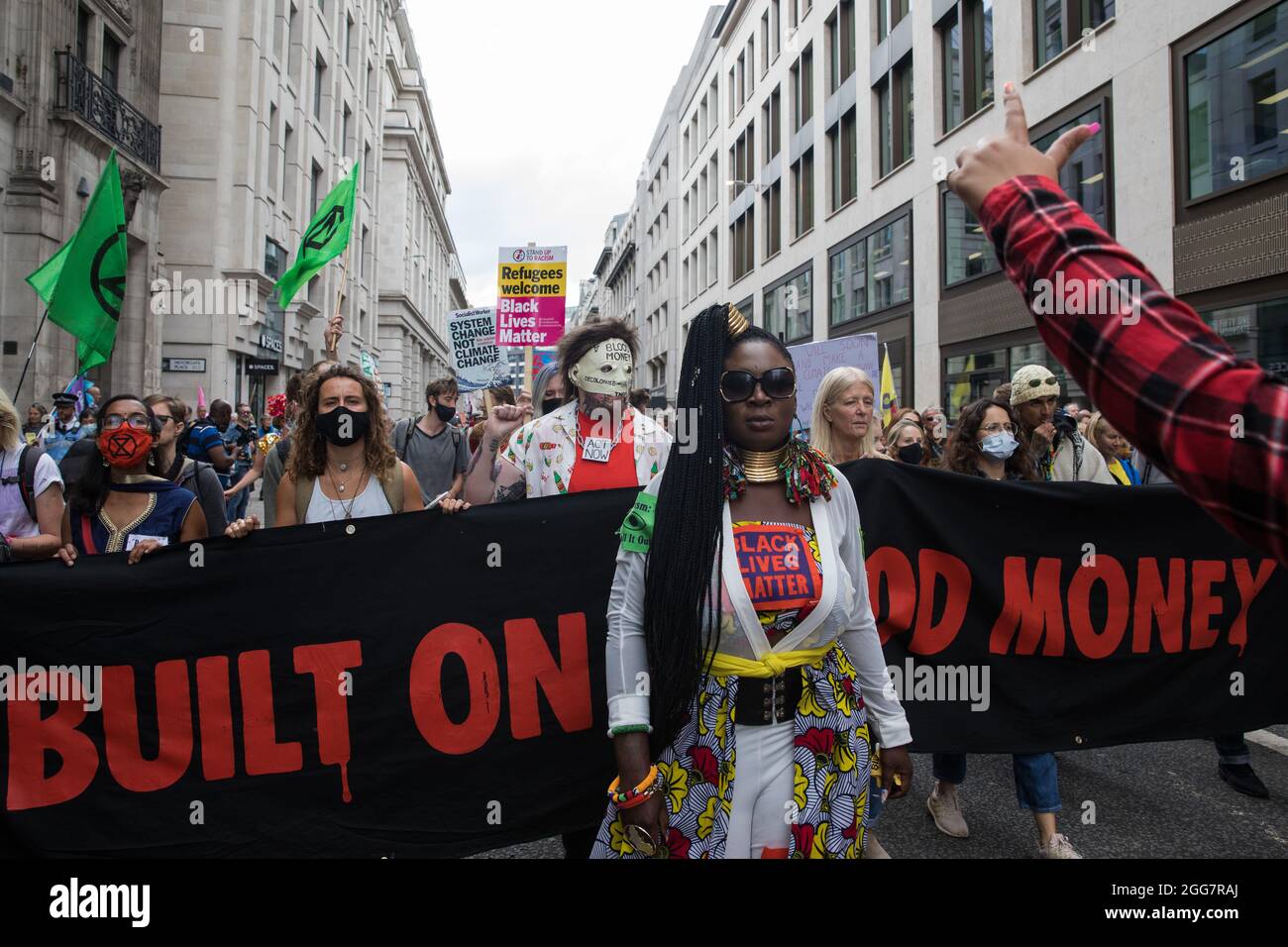 Londra, Regno Unito. 27 agosto 2021. Marvina Newton guida gli attivisti ambientali dalla ribellione dell'estinzione in una marcia Blood Money attraverso la città di Londra il quinto giorno delle proteste impossibili della ribellione. Extinction Rebellion intendevano evidenziare le istituzioni finanziarie che finanziavano progetti sui combustibili fossili, soprattutto nel Sud del mondo, così come gli studi legali e le istituzioni che li agevolano, mentre chiedevano al governo britannico di cessare tutti i nuovi investimenti sui combustibili fossili con effetto immediato. Credit: Mark Kerrison/Alamy Live News Foto Stock
