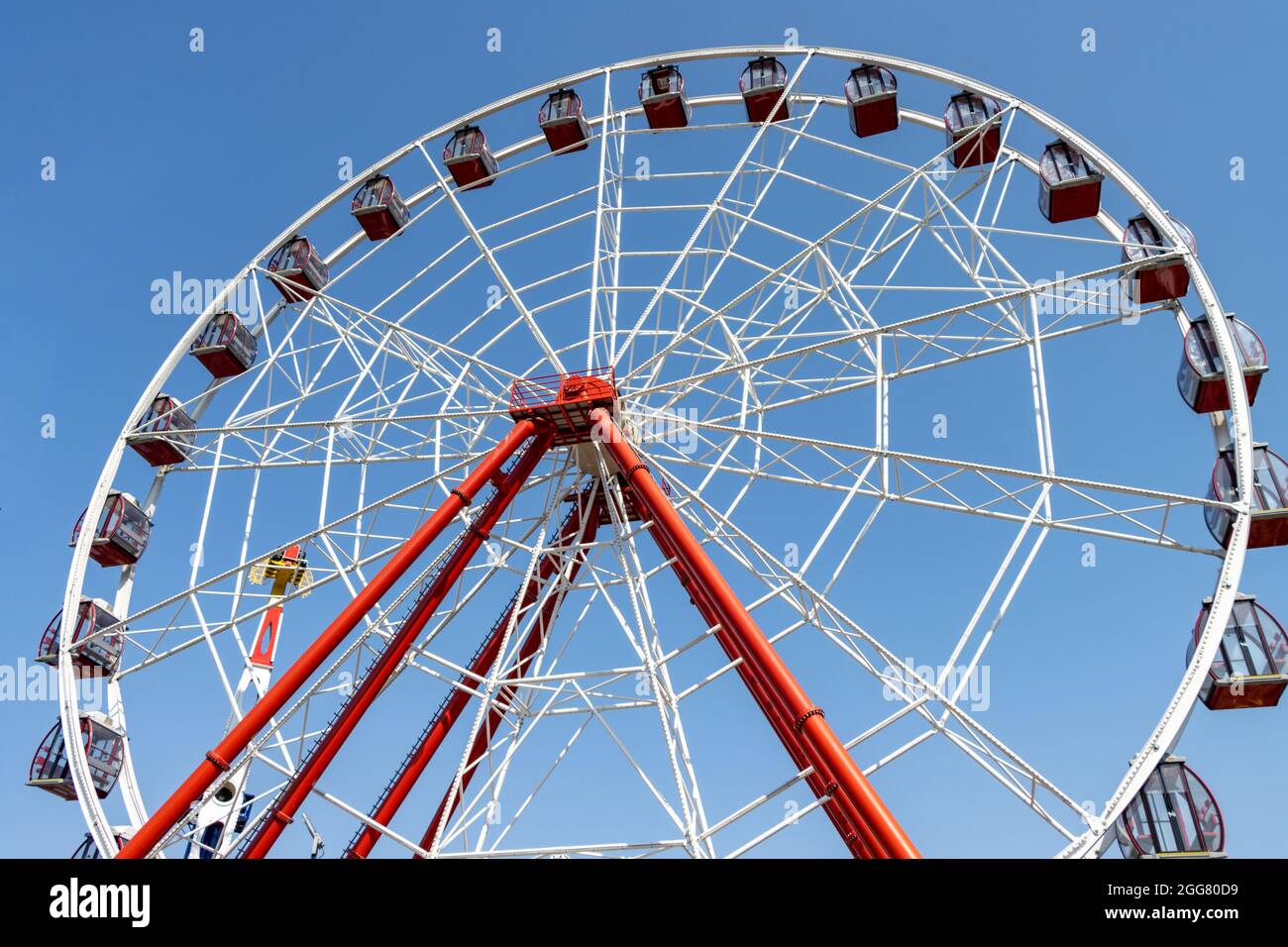 La ruota panoramica gira in una giornata di sole al parco divertimenti. Nessuna gente Foto Stock
