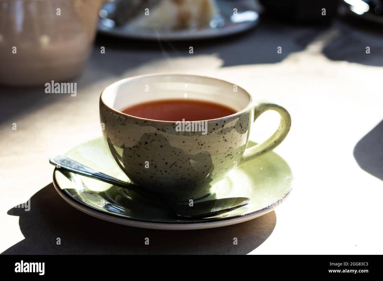 Bere tè nero caldo in una tazza di ceramica verde. Foto Stock