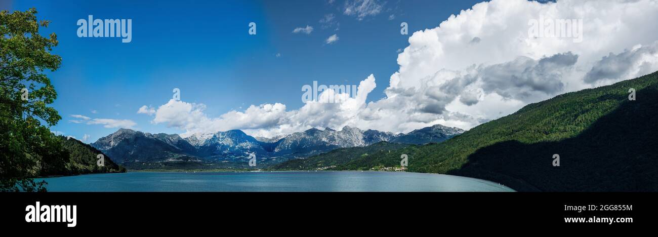 Paesaggio del Lago di Santa Croce nelle Alpi nord-orientali, in Veneto, nel Nord Italia, il cielo è blu con alcune nuvole e l'acqua è ancora. Extrem Foto Stock
