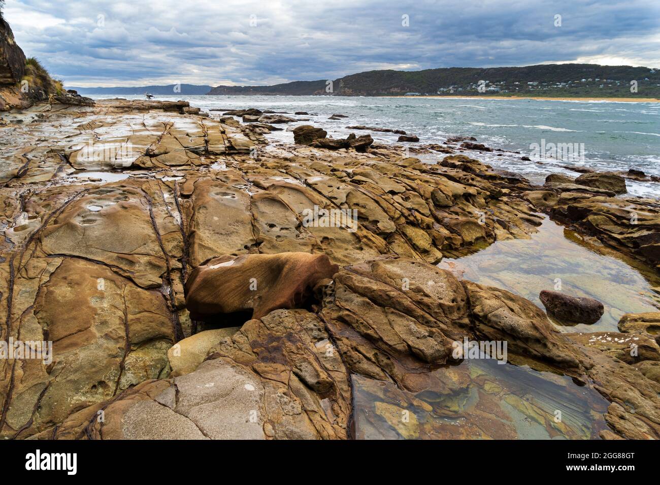 Putty Beach, Central Coast, NSW, Australia in una giornata di tempesta selvaggia con rocce in primo piano Foto Stock