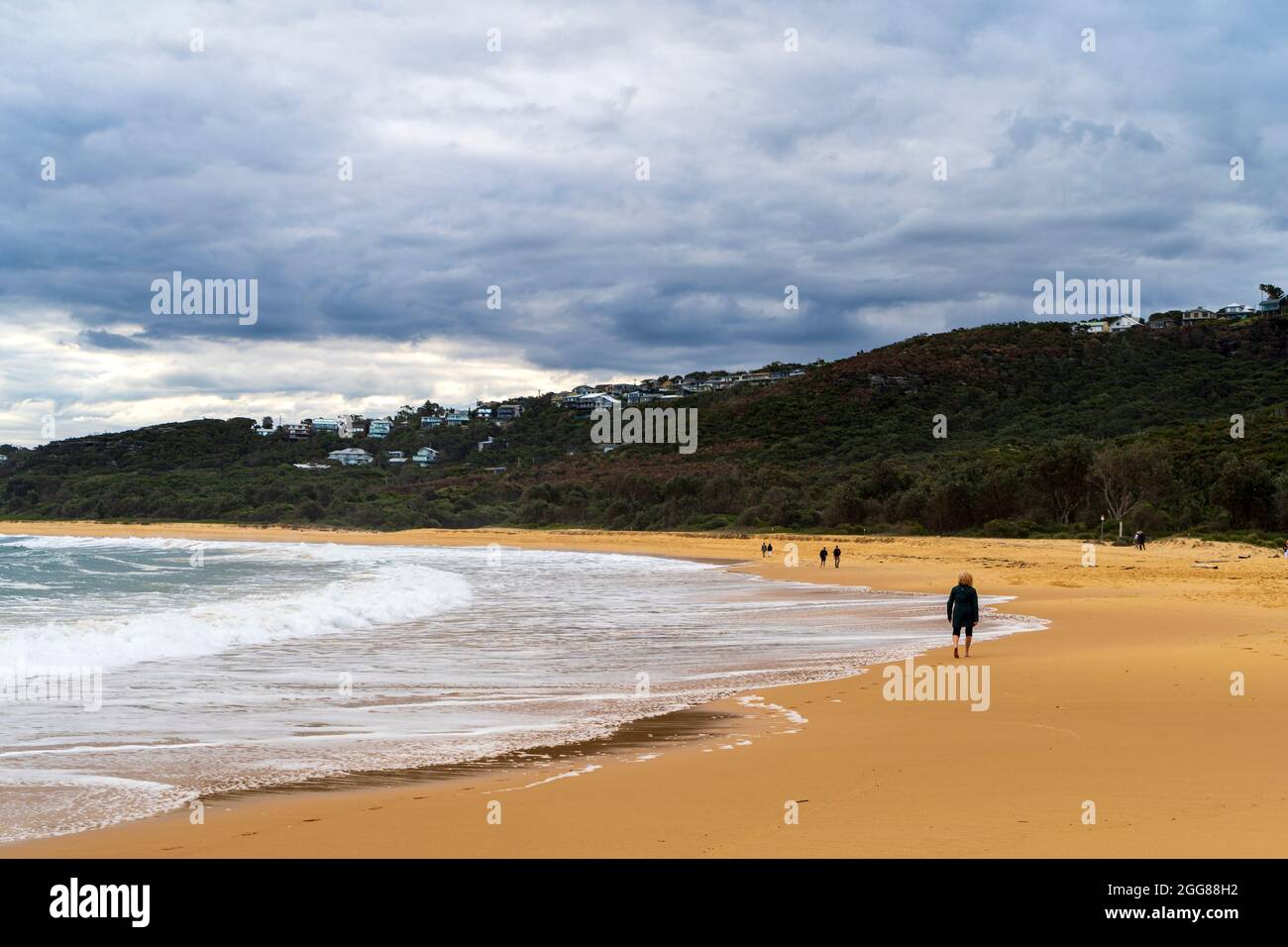 Putty Beach, Central Coast, NSW, Australia in una giornata di tempesta selvaggia con un ampio tiro e camminatori sulla sabbia Foto Stock