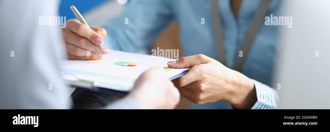 Uomo d'affari firma documento sulla clipboard in mani di segretaria closeup Foto Stock
