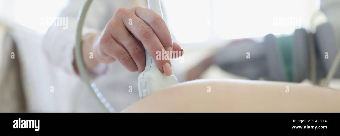 Medico che conduce un esame ecografico del feto di una donna incinta nella clinica closeup Foto Stock