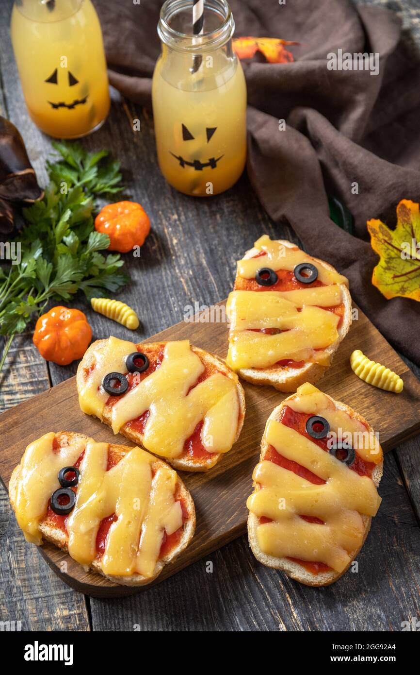 Halloween cibo partito. Halloween mummie mini pizze su un tavolo di legno. Foto Stock