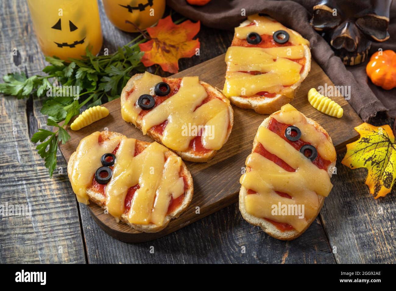 Halloween cibo partito. Halloween mummie mini pizze su un tavolo di legno. Foto Stock