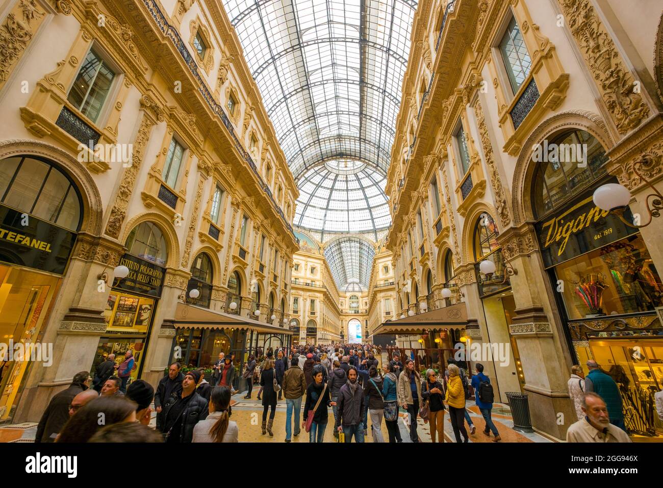 Gente passeggiando e facendo shopping lungo uno dei portici. Presso la Galleria Vittorio Emanuele II di Milano. Foto Stock