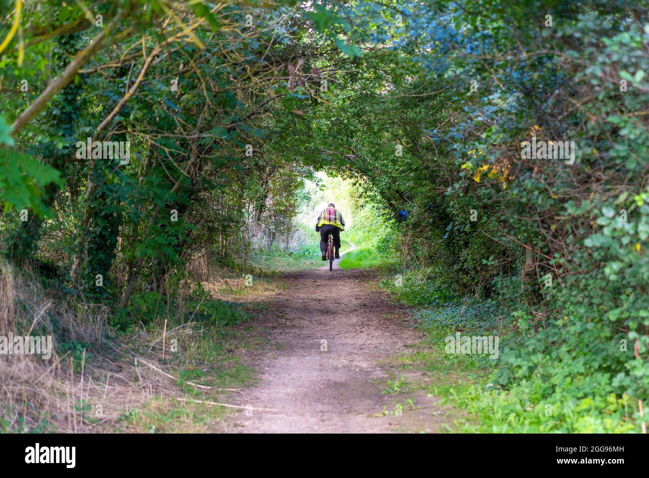 Public Byway Y23 fuori Bath Road Longford vicino all'aeroporto di Heathrow, Regno Unito, un'area verde di percorso con l'autostrada M25. Lavoro pendolari in bicicletta in traforo albero Foto Stock