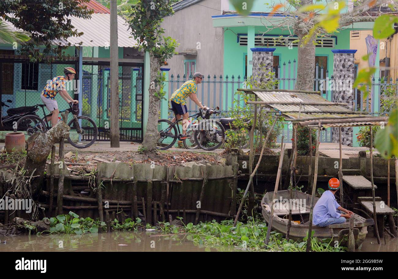 HO chi MINH, VIETNAM - 29 dicembre 2017: Due ciclisti in un tour fluviale lungo il fiume Mekong, ho Chi Minh, Vietnam Foto Stock