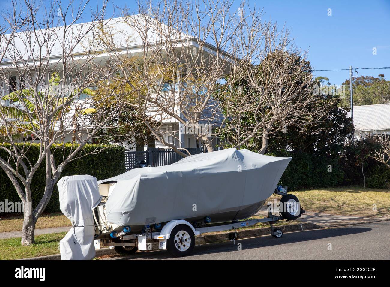 Barca rimorchio immagazzinata su un rimorchio a Palm Beach Sydney con una copertura della barca che protegge la barca, Australia Foto Stock