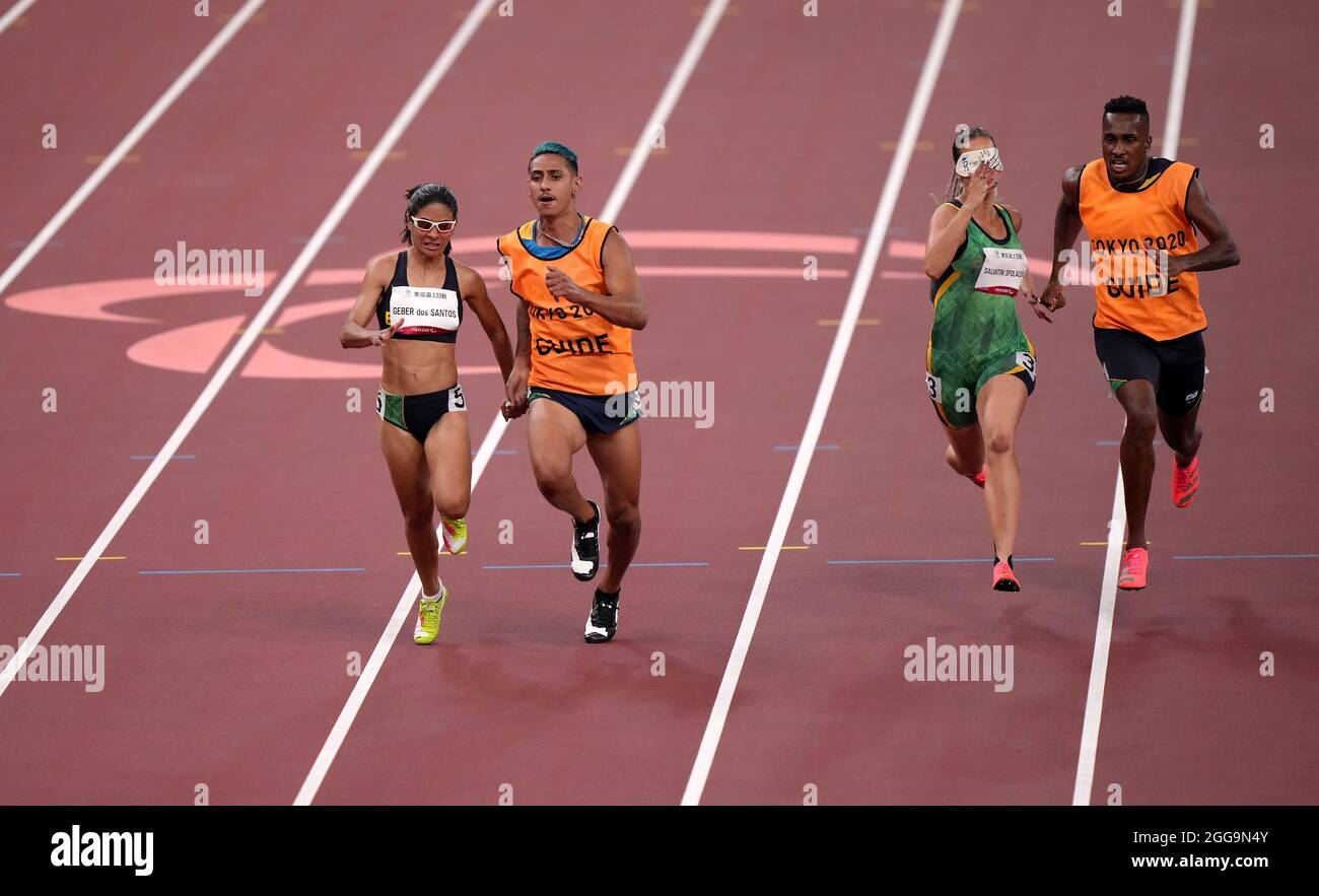 Jerusa Geber Dos Santos in Brasile e guida Gabriel Aparecido Dos Santos Garcia sulla strada per vincere la semifinale femminile 100m - T11 durante l'Atletica allo Stadio Olimpico il sesto giorno dei Giochi Paralimpici di Tokyo 2020 in Giappone. Data foto: Lunedì 30 agosto 2021. Foto Stock