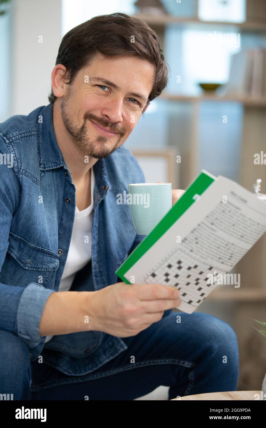 uomo che fa le sue parole incrociate a casa - rilassante Foto Stock
