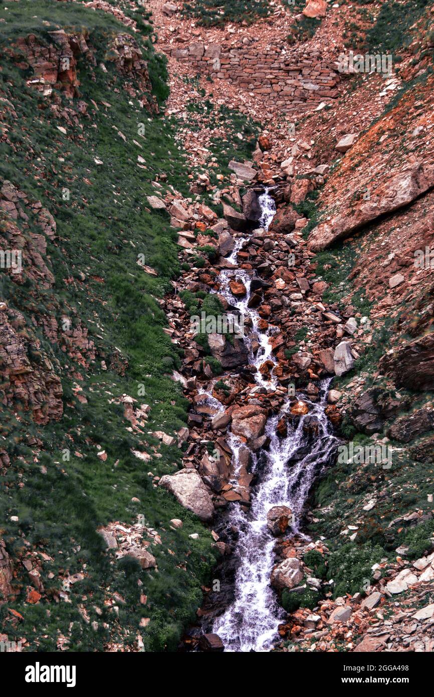 Vista di un'inondazione d'acqua attraverso lo stretto torrente nel Parco Nazionale del Gran Paradiso nelle Alpi italiane Foto Stock