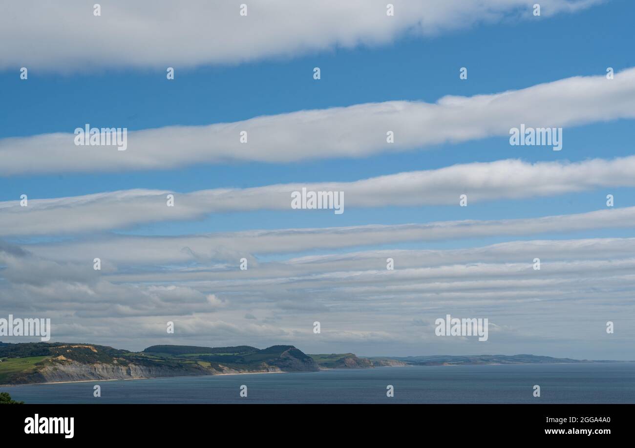 Lyme Regis, Dorset, Regno Unito. 30 ago 2021. UK Meteo: Nuvole chiaro sopra la costa Jurassic e Lyme Regis creazione di strisce nel cielo. Credit: Celia McMahon/Alamy Live News Foto Stock