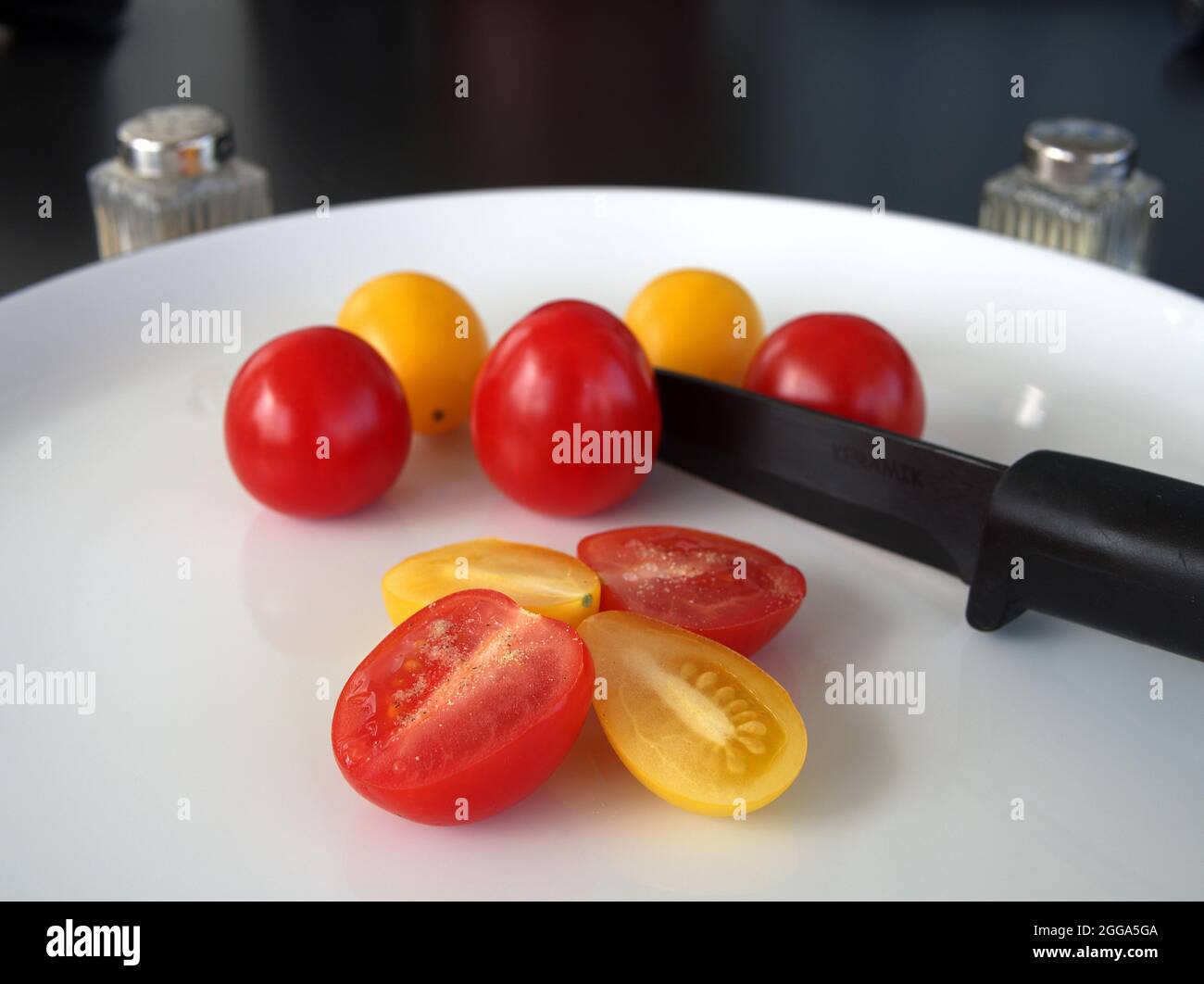 Cocktail di pomodori con sale e pepe e un coltello. Foto Stock