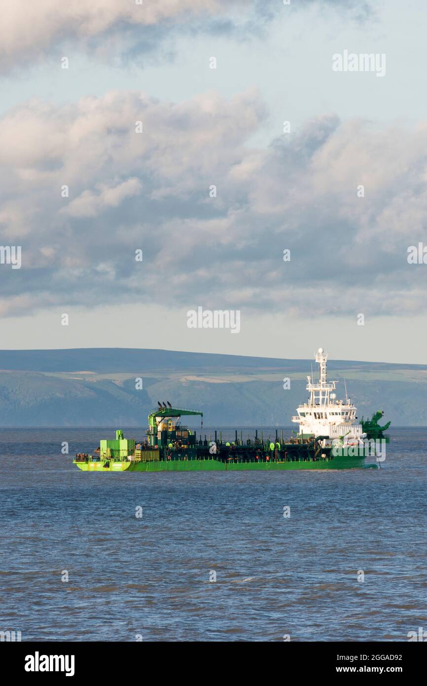 Dredger, l'Artevelde, nel canale di Bristol al largo della costa di Barry vicino a Cardiff. Somerset visibile sullo sfondo. Foto Stock