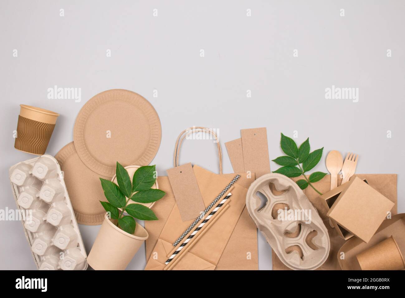 Confezione ecologica sostenibile e set da tavola - imballaggio alimentare in carta kraft su sfondo grigio con spazio per la copia. Imballaggio di carta per alimenti per la strada - Foto Stock