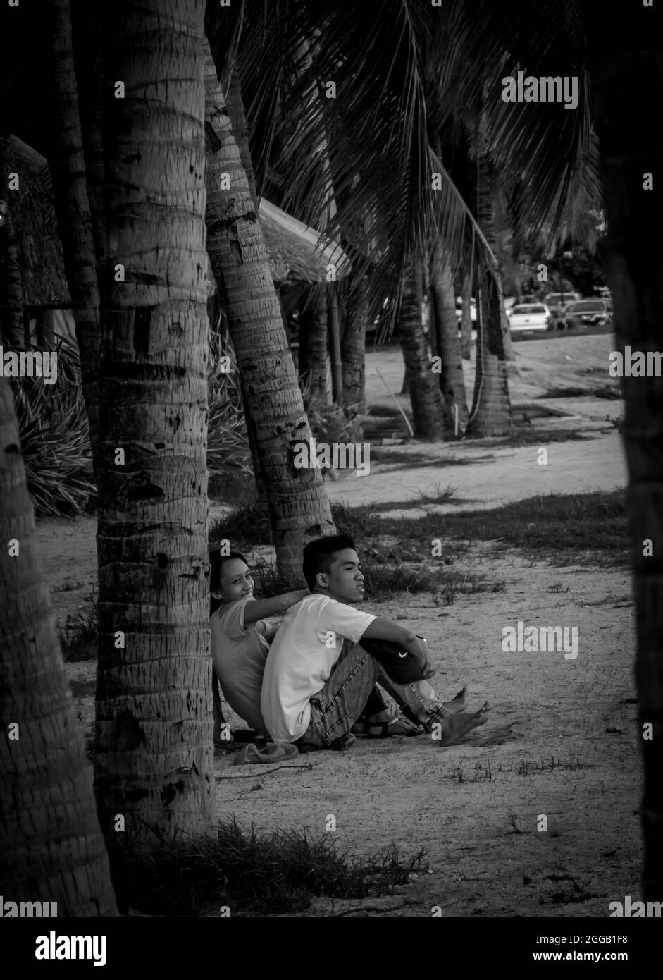 SUBIC, FILIPPINE - ago 01, 2017: Una vista in scala grigia di una coppia filippina che risale seduta alla spiaggia di SMBA in Olongapo City Zambales. Foto Stock