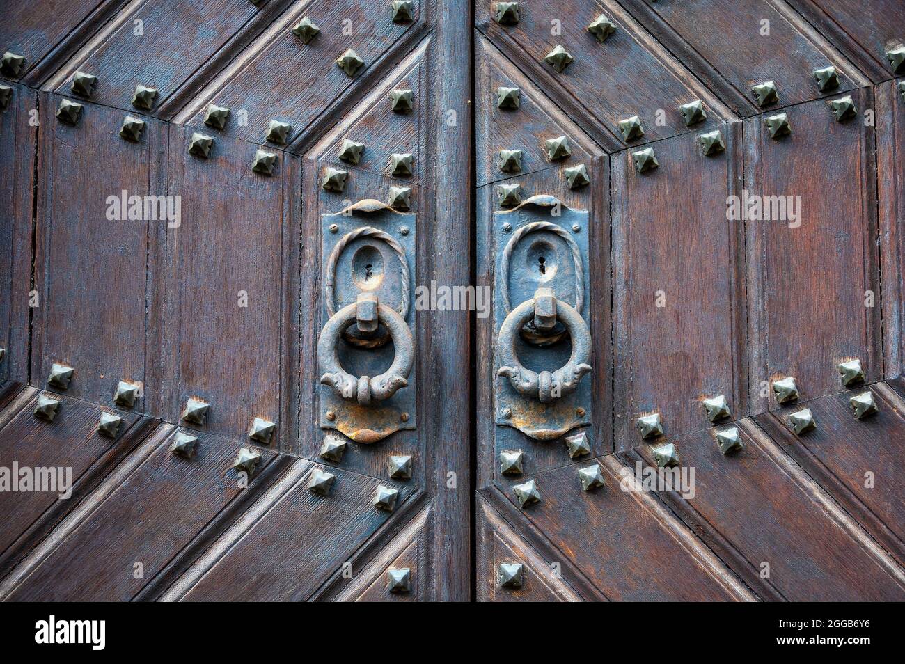 Storica porta in legno con finiture in metallo resistente alle intemperie e porte d'epoca Foto Stock