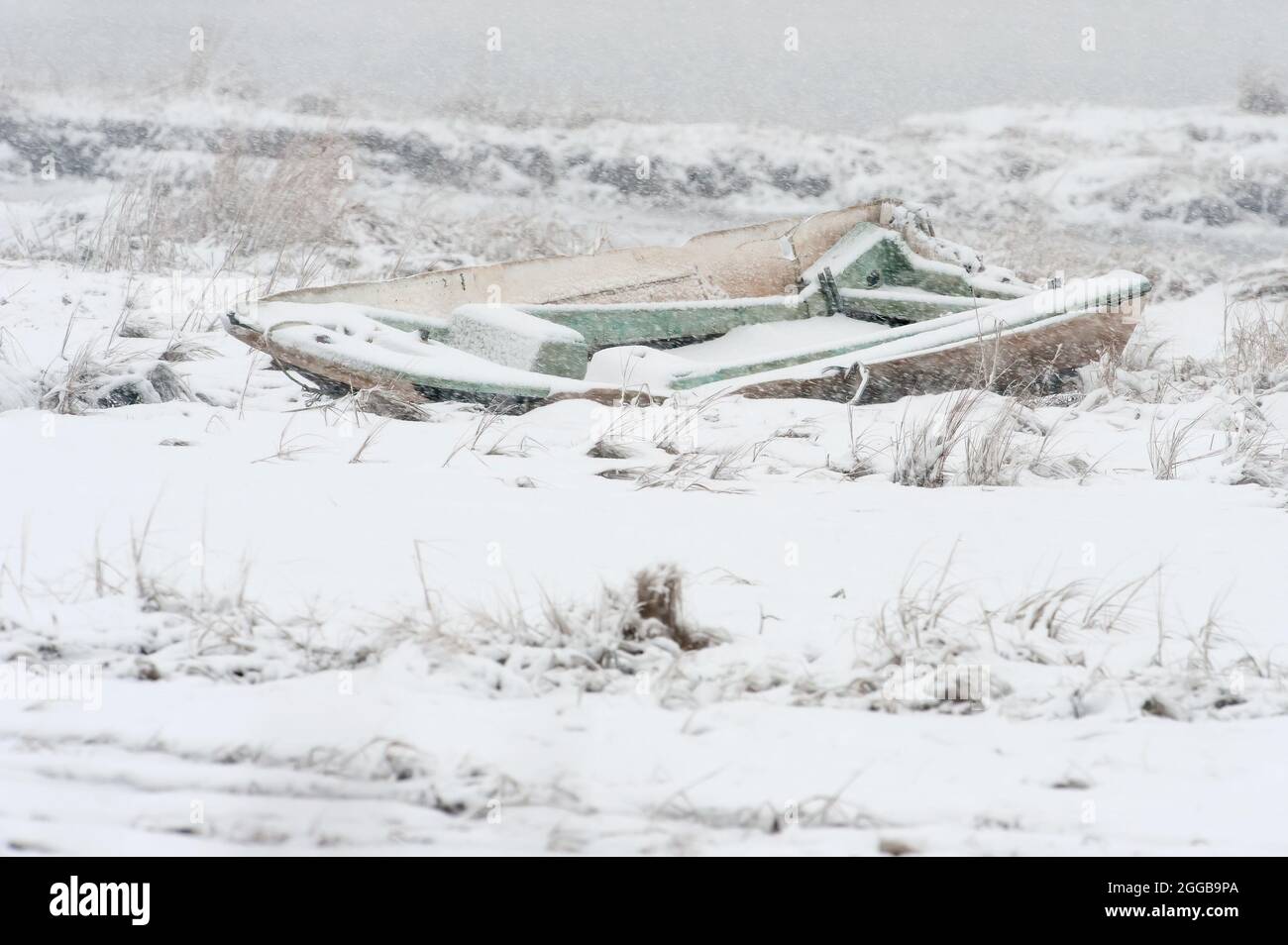 Barca a trefoli in legno nel paesaggio invernale delle paludi saline Foto Stock